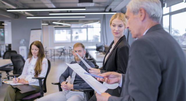 New Executive Search - young-businesswoman-looking-senior-businessman-pointing-documents-his-hand copy